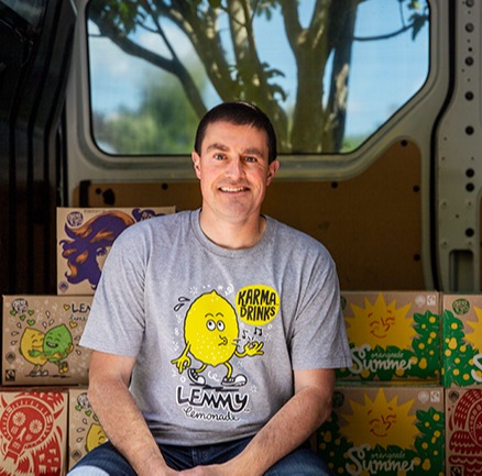 Patrick Coyle from Karma Cola sittign in a truck next to some boxes of drinks