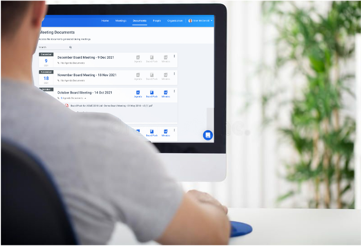 A man sitting at a desktop computer using BoardPro to search the meeting documents for key information