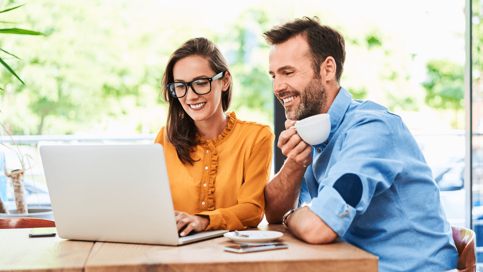 two colleagues discussing work over a laptop