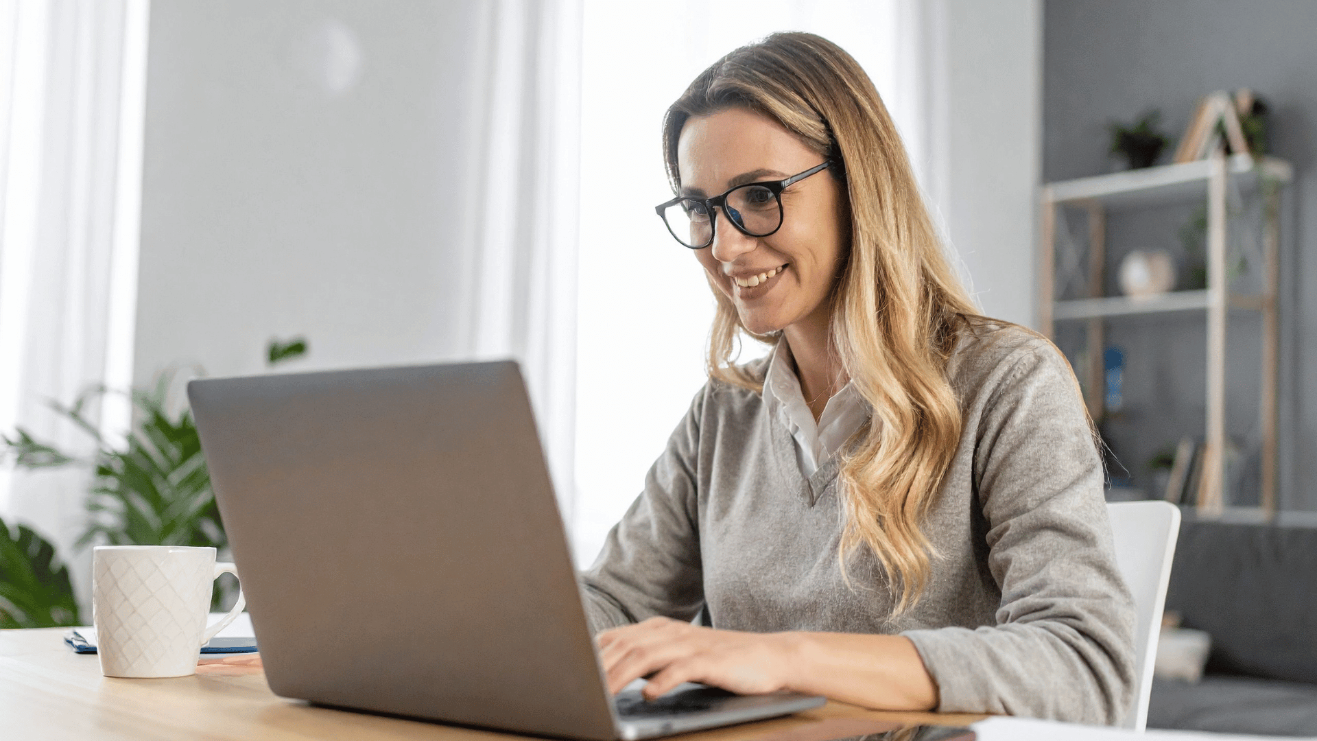 woman working at laptop on board papers