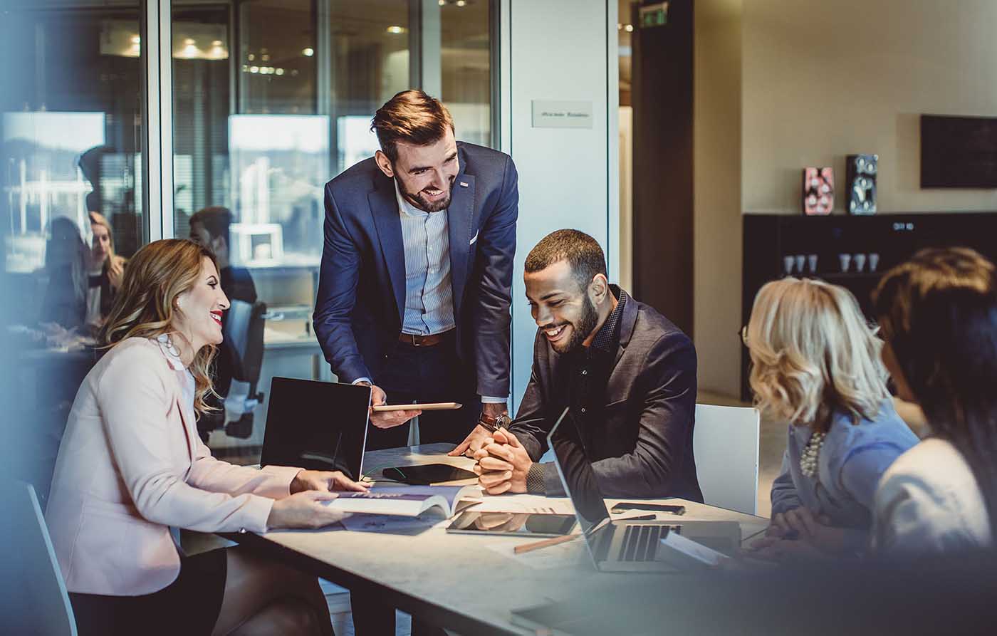 people leaning over a desk discussing board matters